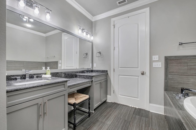 bathroom with tiled tub, ornamental molding, and vanity