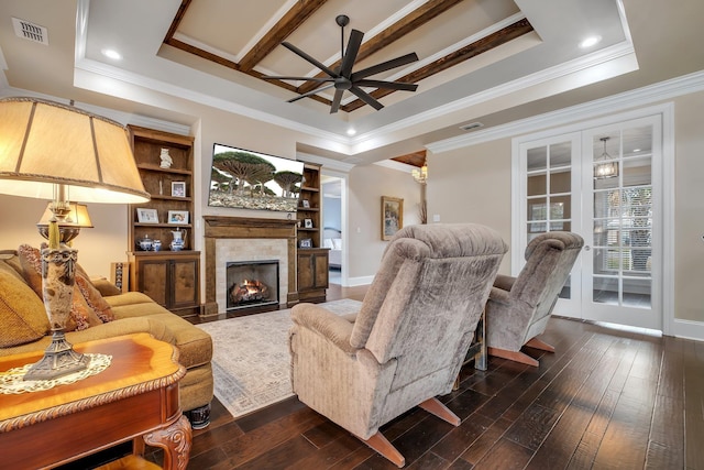 living room with crown molding, a fireplace, dark hardwood / wood-style flooring, and a raised ceiling