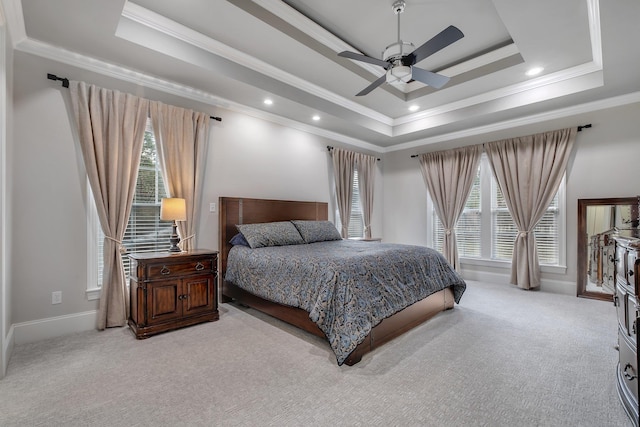 bedroom with a raised ceiling, crown molding, and light colored carpet