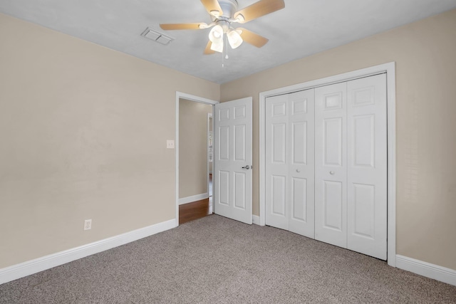 unfurnished bedroom with carpet, a closet, visible vents, ceiling fan, and baseboards