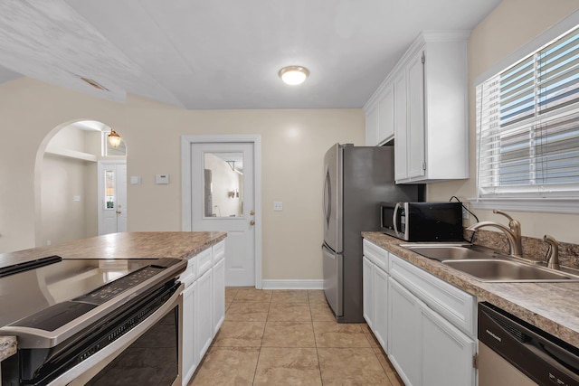 kitchen featuring appliances with stainless steel finishes, white cabinetry, and a sink