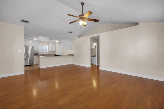 unfurnished living room with ceiling fan, wood finished floors, visible vents, and baseboards