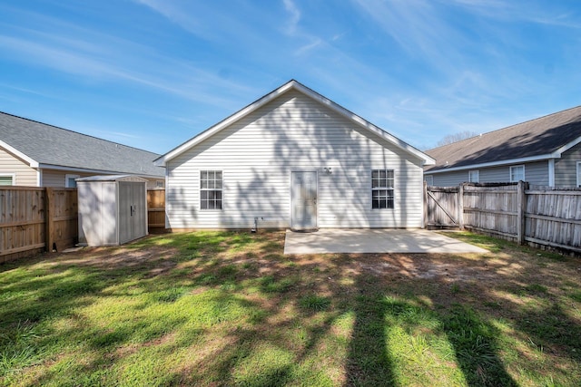 back of house featuring a storage shed, a patio, a yard, and a fenced backyard