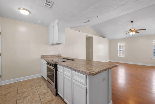 kitchen featuring visible vents, open floor plan, white cabinets, a peninsula, and stainless steel electric range