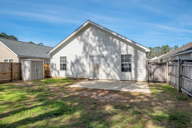 back of house with a gate, a fenced backyard, a patio, and a storage shed