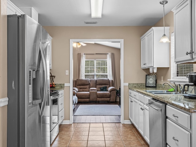 100 Ej Stringer Rd, Crawfordville, FL 32327 - kitchen with appliances with stainless steel finishes, open floor plan, white cabinets, pendant lighting, and light tile patterned flooring