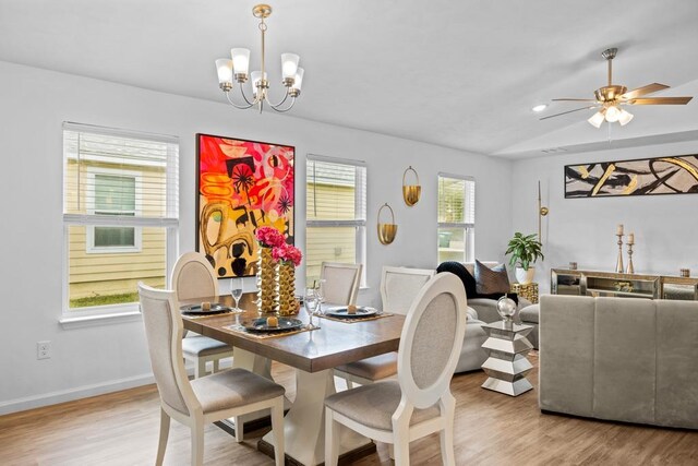 dining space with light hardwood / wood-style flooring, ceiling fan with notable chandelier, and plenty of natural light