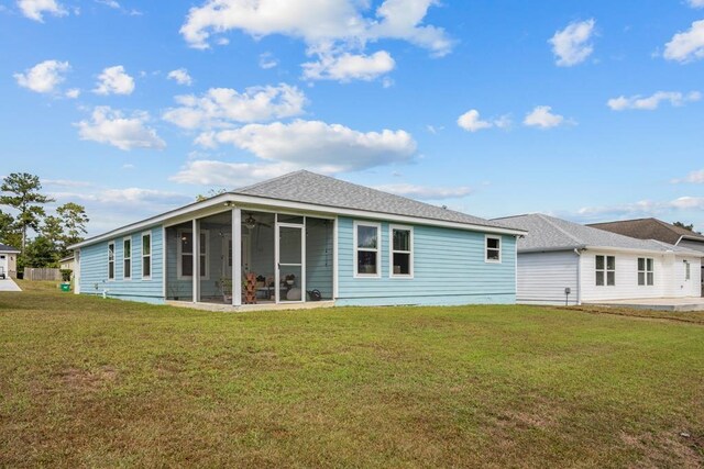 back of house featuring a lawn and a sunroom