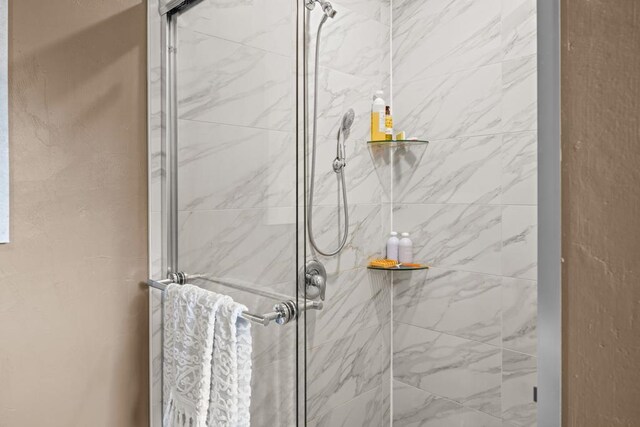 bathroom with a shower with door