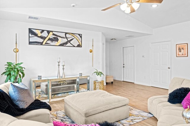 living room with light hardwood / wood-style floors, ceiling fan, and vaulted ceiling