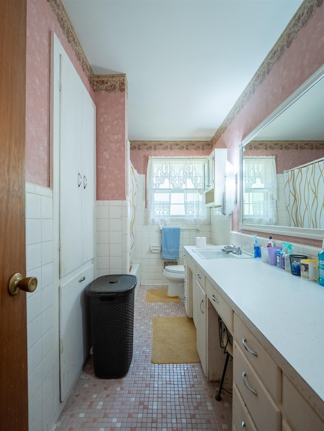 3364 NW 66th Blvd, Jennings, FL 32053 - bathroom featuring tile walls, toilet, vanity, a wainscoted wall, and tile patterned floors