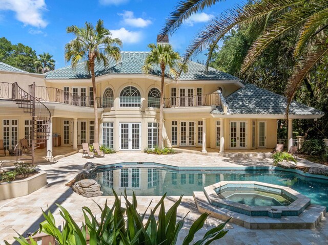3899 W Millers Bridge Rd, Tallahassee, FL 32312 - back of house featuring french doors, a balcony, a patio, a pool with connected hot tub, and stucco siding