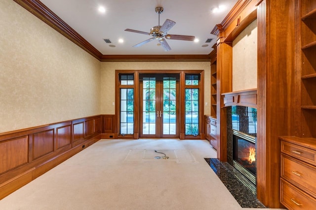 3899 W Millers Bridge Rd, Tallahassee, FL 32312 - doorway featuring crown molding, a fireplace, a decorative wall, ceiling fan, and a wainscoted wall