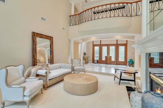 3899 W Millers Bridge Rd, Tallahassee, FL 32312 - living room featuring french doors, arched walkways, a glass covered fireplace, a high ceiling, and ornate columns