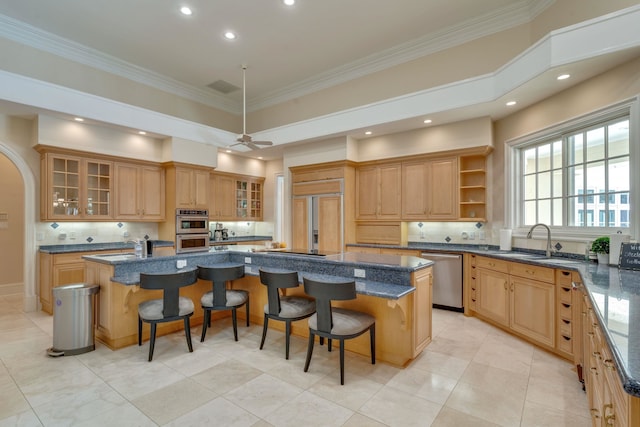 3899 W Millers Bridge Rd, Tallahassee, FL 32312 - kitchen featuring appliances with stainless steel finishes, a large island with sink, decorative backsplash, a breakfast bar area, and ornamental molding