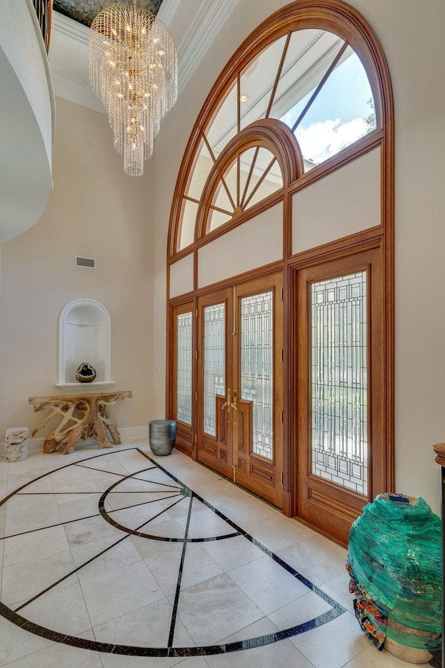 3899 W Millers Bridge Rd, Tallahassee, FL 32312 - tiled foyer entrance featuring french doors, a chandelier, a high ceiling, inlaid floor details, and crown molding