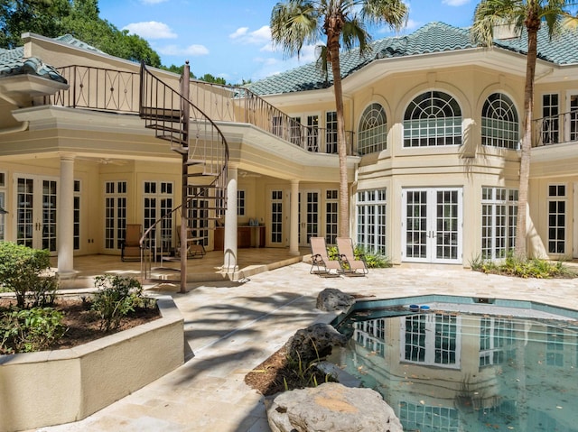 3899 W Millers Bridge Rd, Tallahassee, FL 32312 - back of property featuring french doors, a patio, an outdoor pool, stairway, and a tile roof