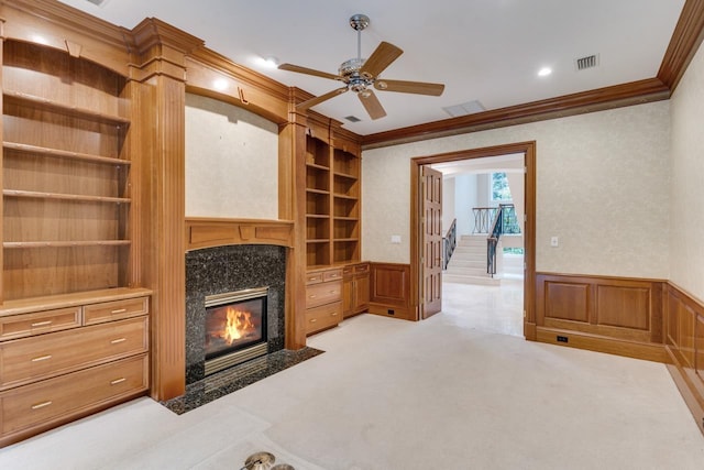 3899 W Millers Bridge Rd, Tallahassee, FL 32312 - unfurnished living room featuring crown molding, built in features, a ceiling fan, a wainscoted wall, and a fireplace