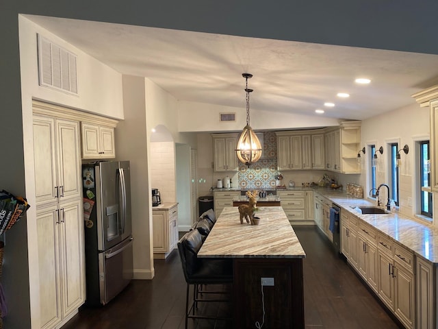 kitchen with a center island, sink, hanging light fixtures, decorative backsplash, and stainless steel appliances