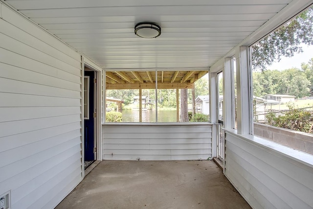 unfurnished sunroom featuring a water view