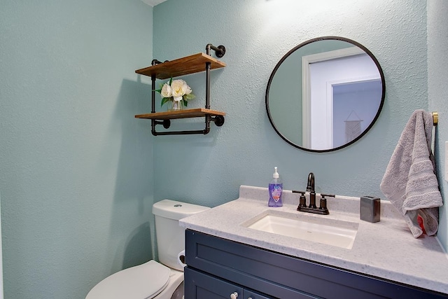 bathroom featuring toilet and vanity