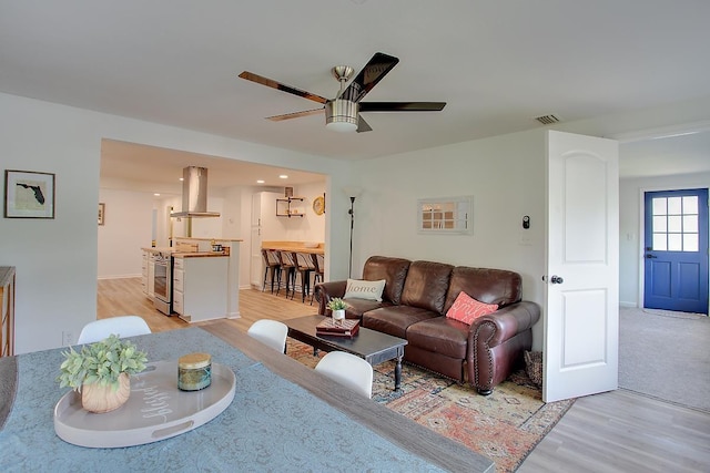 living room featuring ceiling fan and light hardwood / wood-style floors