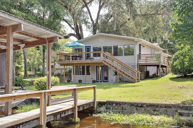 back of house featuring a yard and a deck with water view