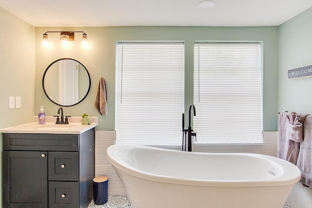 bathroom with a tub and vanity