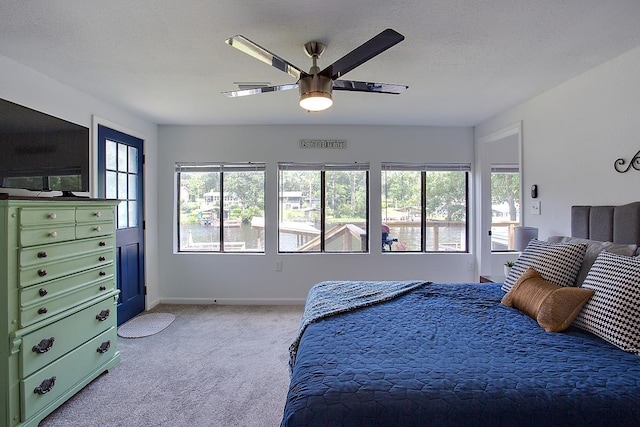 carpeted bedroom with multiple windows, a textured ceiling, and ceiling fan