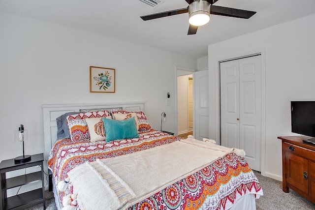 carpeted bedroom with ceiling fan and a closet