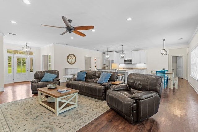 living room featuring dark wood-type flooring, recessed lighting, visible vents, and ornamental molding