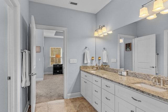 bathroom with visible vents, a sink, baseboards, and double vanity