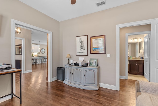 corridor with baseboards, visible vents, and wood finished floors