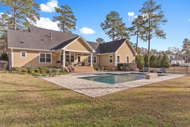 back of property with a lawn, a patio area, fence, and a fenced in pool