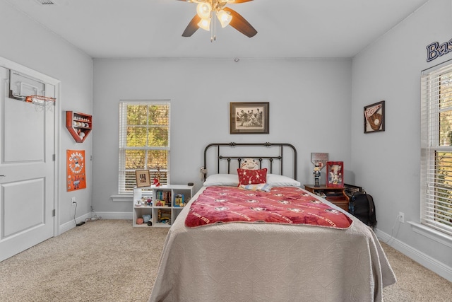 carpeted bedroom with ceiling fan and baseboards