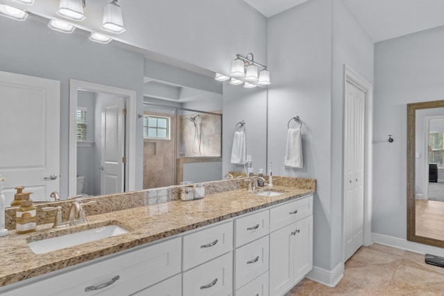 full bath featuring toilet, a sink, a closet, a shower stall, and double vanity