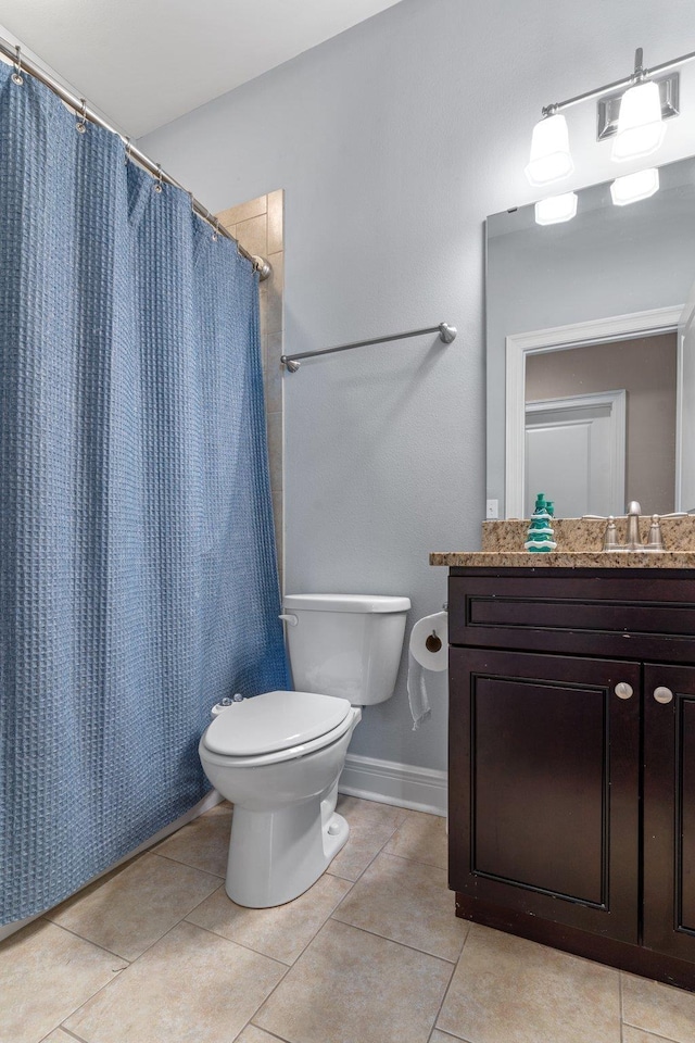 full bathroom featuring toilet, vanity, baseboards, and tile patterned floors