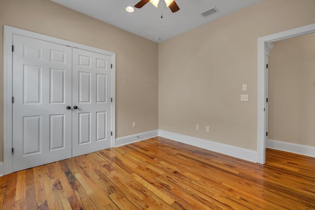 unfurnished bedroom featuring ceiling fan, a closet, and light hardwood / wood-style flooring