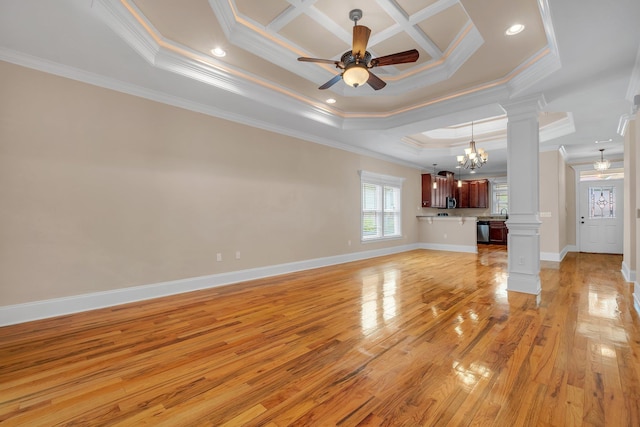 unfurnished living room featuring decorative columns, crown molding, a tray ceiling, ceiling fan with notable chandelier, and light wood-type flooring