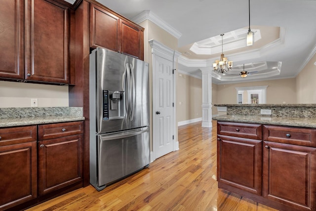 kitchen with a tray ceiling, stainless steel fridge with ice dispenser, decorative columns, and crown molding