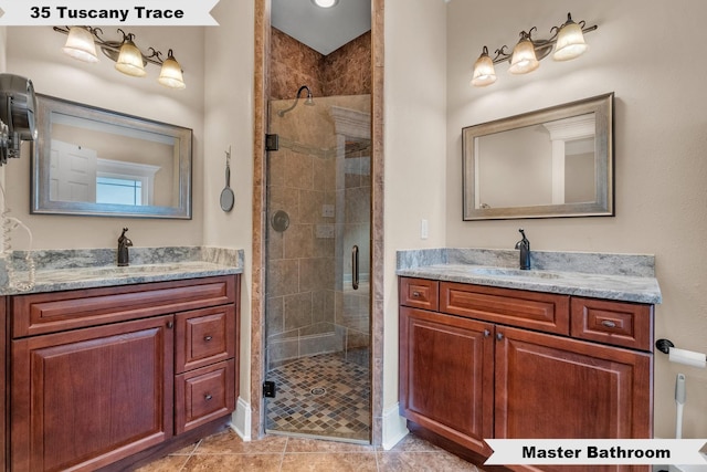 bathroom with tile patterned floors, vanity, and walk in shower