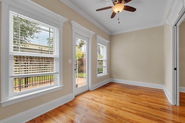 doorway to outside featuring light wood-type flooring, ceiling fan, and crown molding