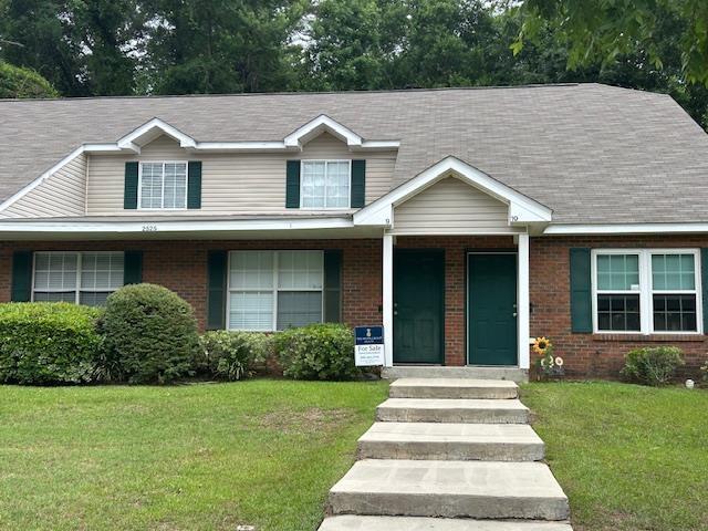 view of front of house featuring brick siding and a front yard