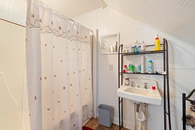 bathroom with lofted ceiling, sink, and walk in shower