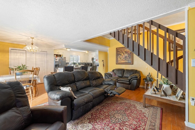 living room with hardwood / wood-style floors, a notable chandelier, and a textured ceiling