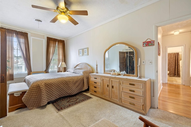 bedroom featuring ornamental molding, ceiling fan, a textured ceiling, and light hardwood / wood-style floors