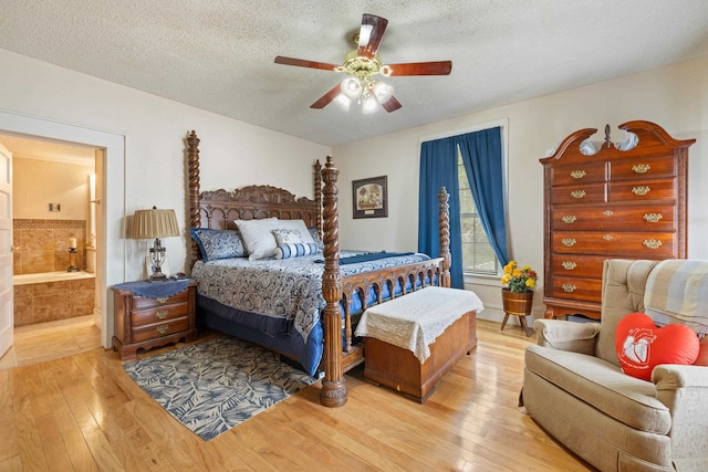 bedroom with hardwood / wood-style flooring, ceiling fan, ensuite bathroom, and a textured ceiling