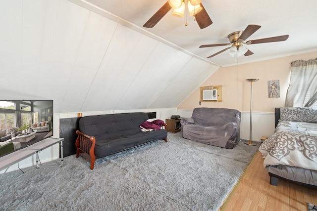 bedroom featuring crown molding, a wall mounted air conditioner, vaulted ceiling, hardwood / wood-style flooring, and ceiling fan