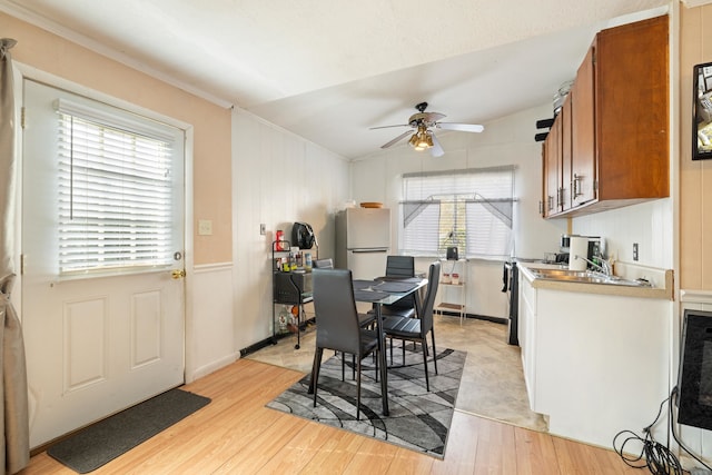 dining space featuring ceiling fan, ornamental molding, and light hardwood / wood-style floors