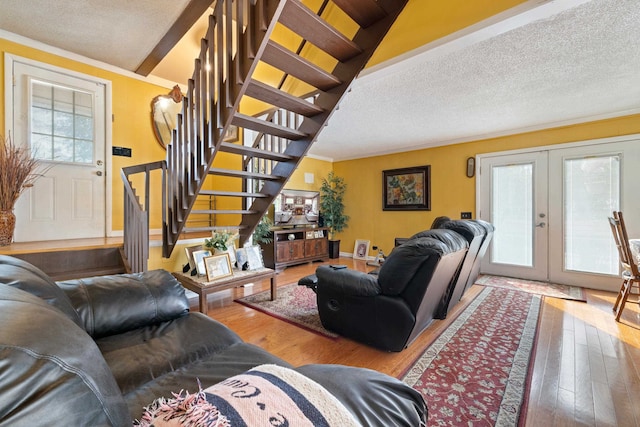 living room featuring hardwood / wood-style flooring, a wealth of natural light, a textured ceiling, and french doors